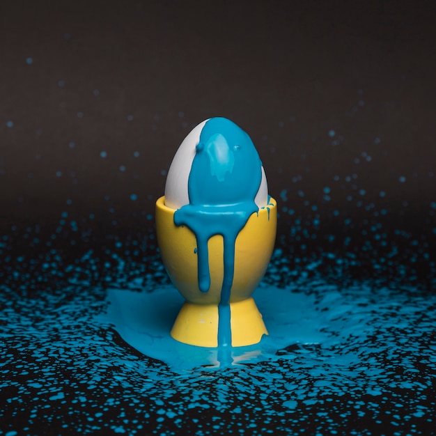 Яйцо с высоким углом на подставке с синей краской