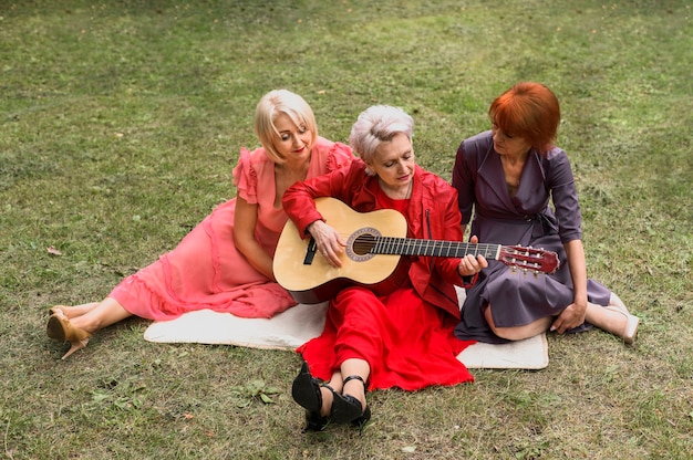 Free photo high angle elderly women playing music