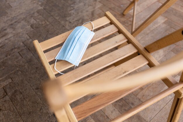 high angle of empty chair with medical mask prepared for group therapy session