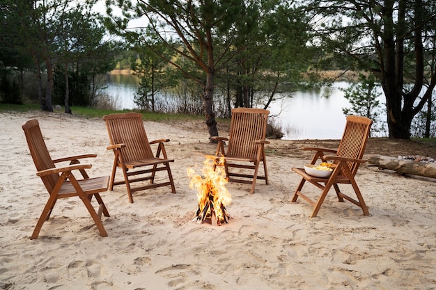 High angle empty chairs around bonfire