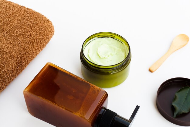 High angle of essential oil bottle and cream on white background