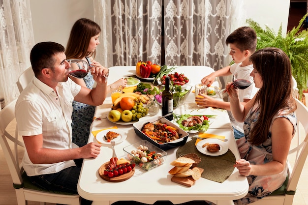 Высокий угол семьи едят за обеденным столом