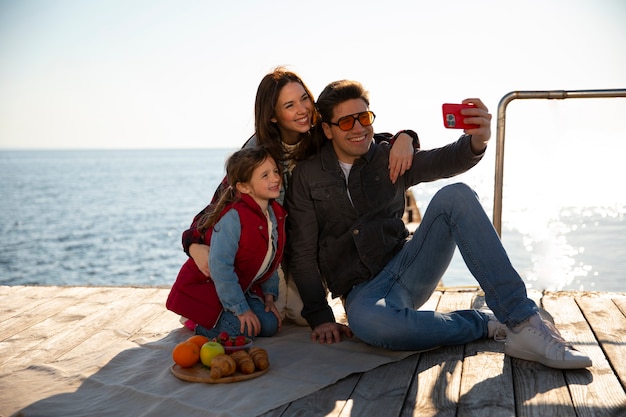 Foto gratuita famiglia ad alto angolo che va in giro su un molo