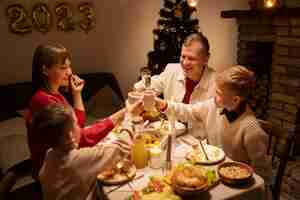 Free photo high angle family members clinking glasses