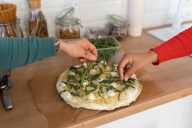 Foto gratuita famiglia ad alto angolo con una deliziosa pizza