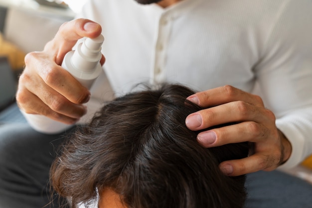 Free photo high angle father applying lice treatment