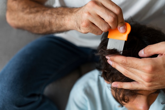 High angle father holding lice comb