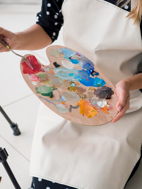 High angle of female artist holding paint palette