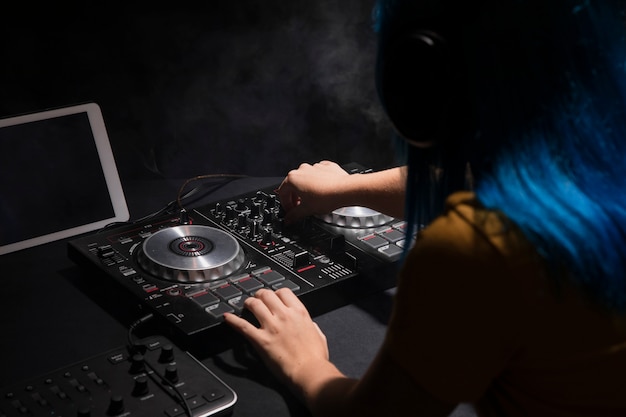 High angle female dj at mixing panel