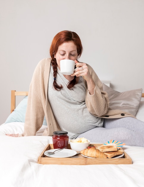 Free photo high angle female enjoying brunch in bed