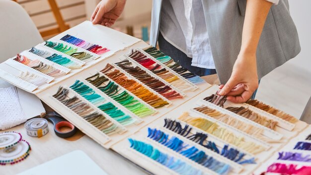 High angle of female fashion designer consulting color palette for clothing line