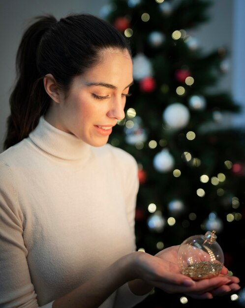 Высокий угол женщина держит рождественские украшения глобус