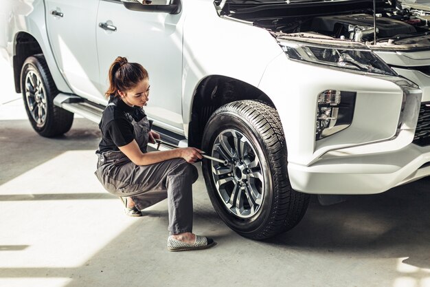 High angle female mechanic taking out wheel