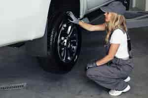 Бесплатное фото Высокий угол женского ремонта автомобиля на службе