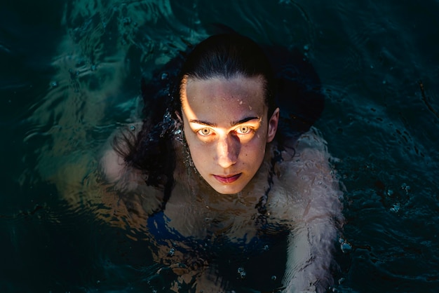 Free photo high angle of female swimmer posing in water