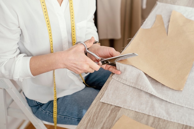 Free photo high angle of female tailor working in the studio