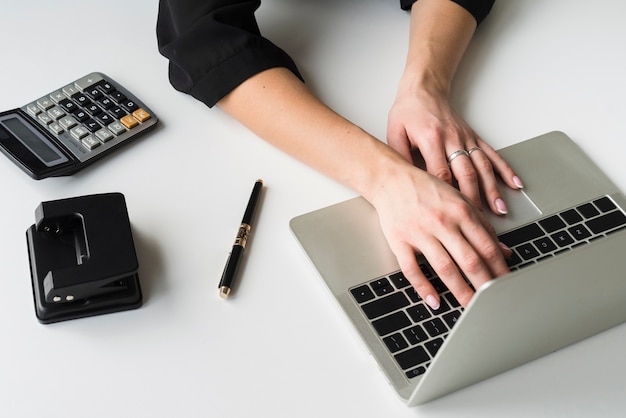 Femmina dell'angolo alto che lavora al computer portatile