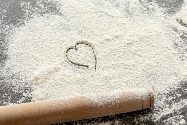 High angle of flour and wooden rolling pin