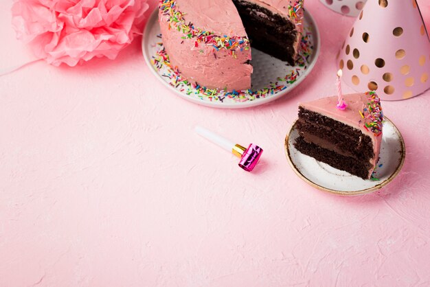 High angle frame with decorations and pink cake