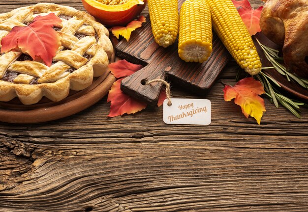 High angle frame with pie and corn on wooden background