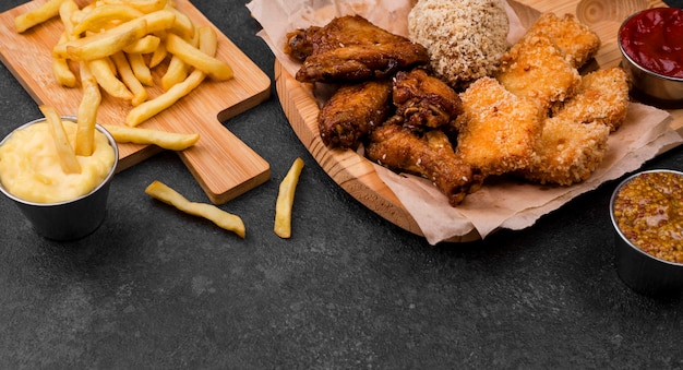 High angle of french fries and fried chicken