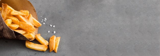 High angle of french fries with salt and copy space