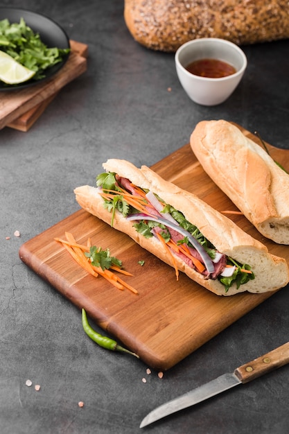 High angle of fresh sandwiches on chopping board with sauce