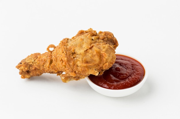 High angle fried chicken drumstick with ketchup