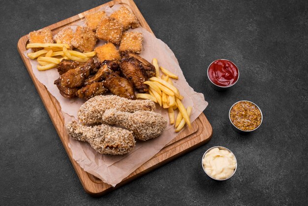 High angle of fried chicken and french fries on chopping board