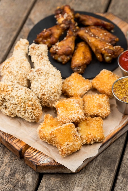 High angle of fried chicken nuggets with variety of sauces