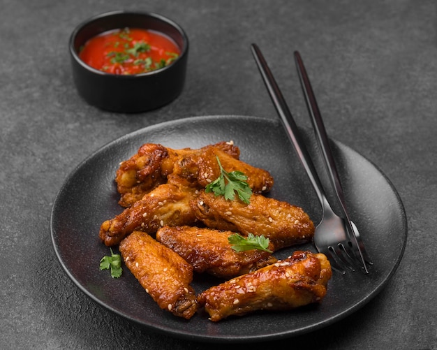 High angle of fried chicken on plate with sauce and cutlery