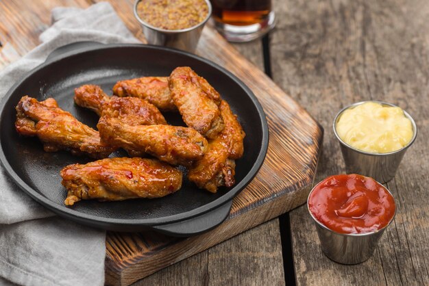 High angle of fried chicken on plate with variety of sauces and fizzy drink