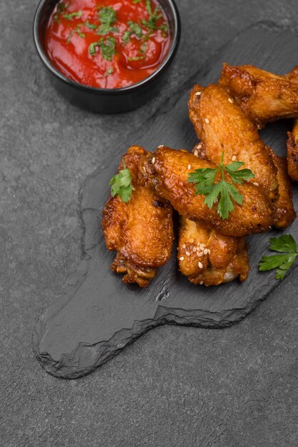 High angle of fried chicken on slate with sauce
