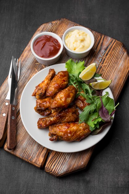 High angle of fried chicken with sauce and salad