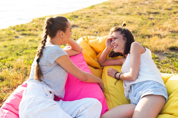 Foto gratuita amici dell'angolo alto che vanno in giro sui beanbag variopinti