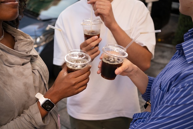 High angle friends holding iced coffee