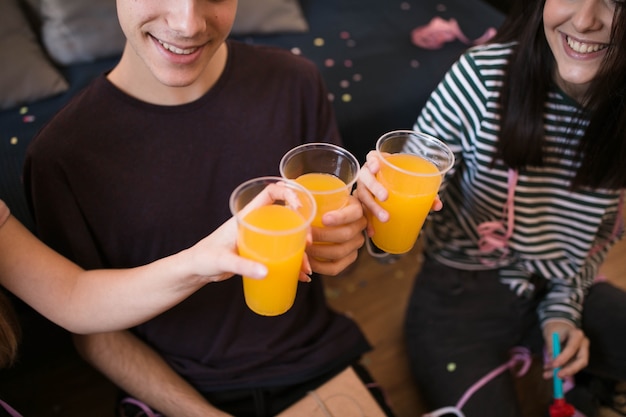 High angle friends toasting soda