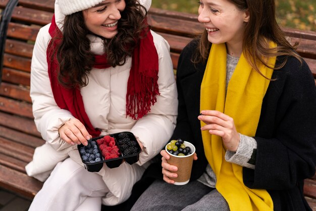 High angle friends with delicious berries in park