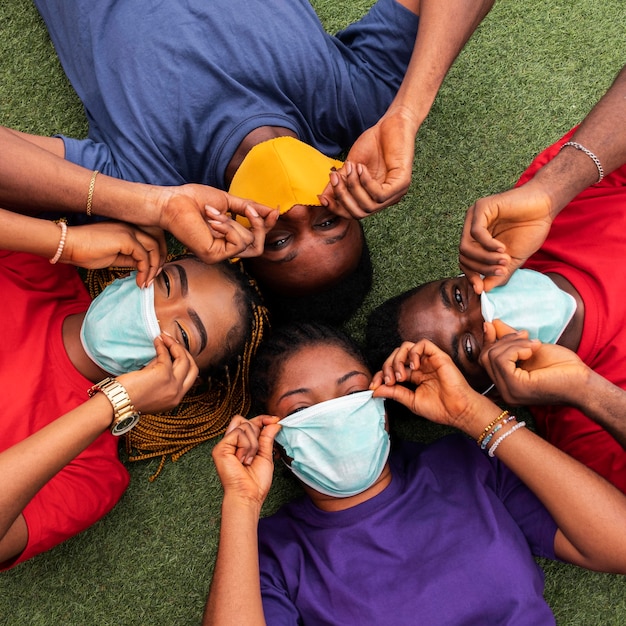 Free photo high angle of friends with face mask concept