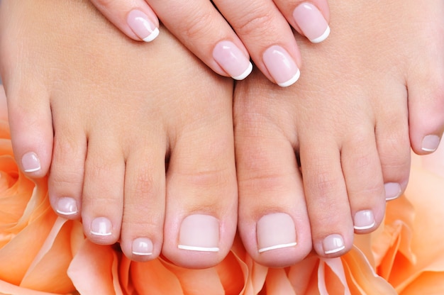 High angle front view of a female clean, pure  feet with french pedicure