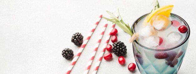 High angle of fruit cocktail glass with copy space and straws