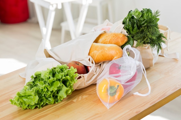 High angle of fruit and vegetables on table with reusable bags