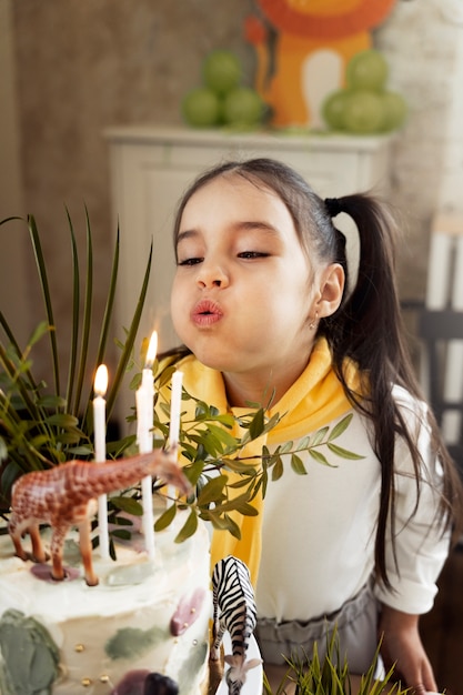 Free photo high angle girl blowing candles