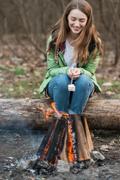 Free photo high angle girl cooking marshmallow