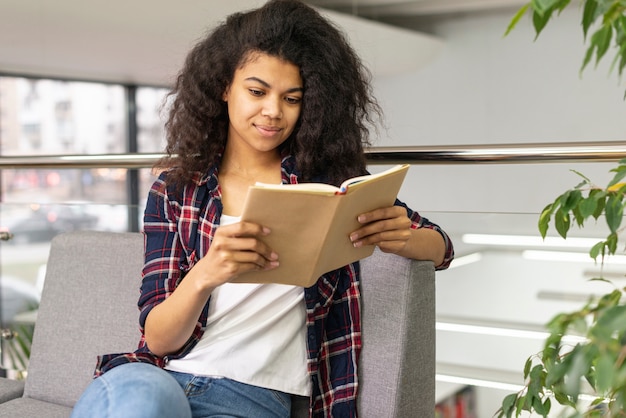 High angle girl on couch reading