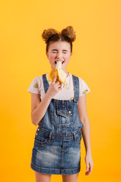 Высокий угол девушка ест банан