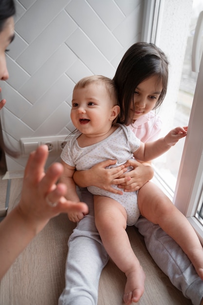 Free photo high angle girl holding baby