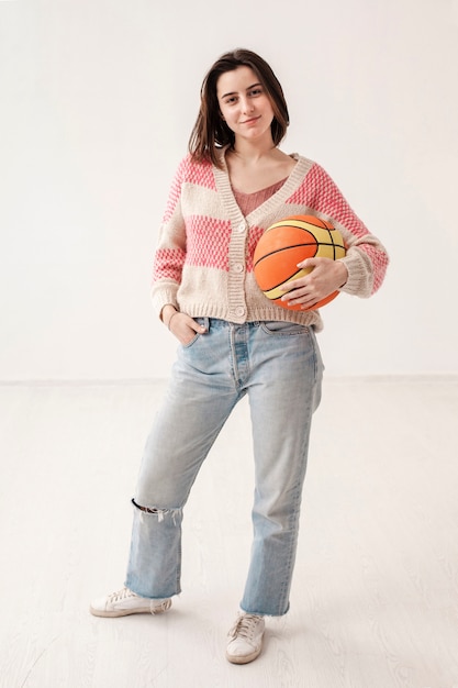 Высокий угол девушка держит баскетбольный мяч