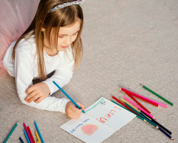 high angle of girl holding drawing card for father's day