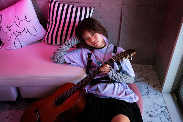 Девушка под высоким углом держит гитару